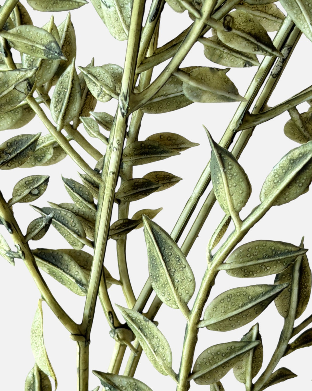 Close-up of Faux Ruscus greenery stems featuring vibrant green leaves and realistic droplet textures, designed for adding dimensional depth to sola flower bouquets